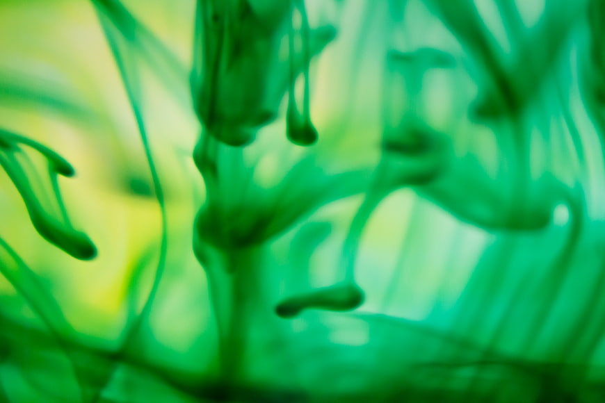 Abstract green ink swirling in water background