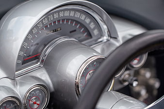 Close-up of vintage silver car dashboard with speedometer and gauges