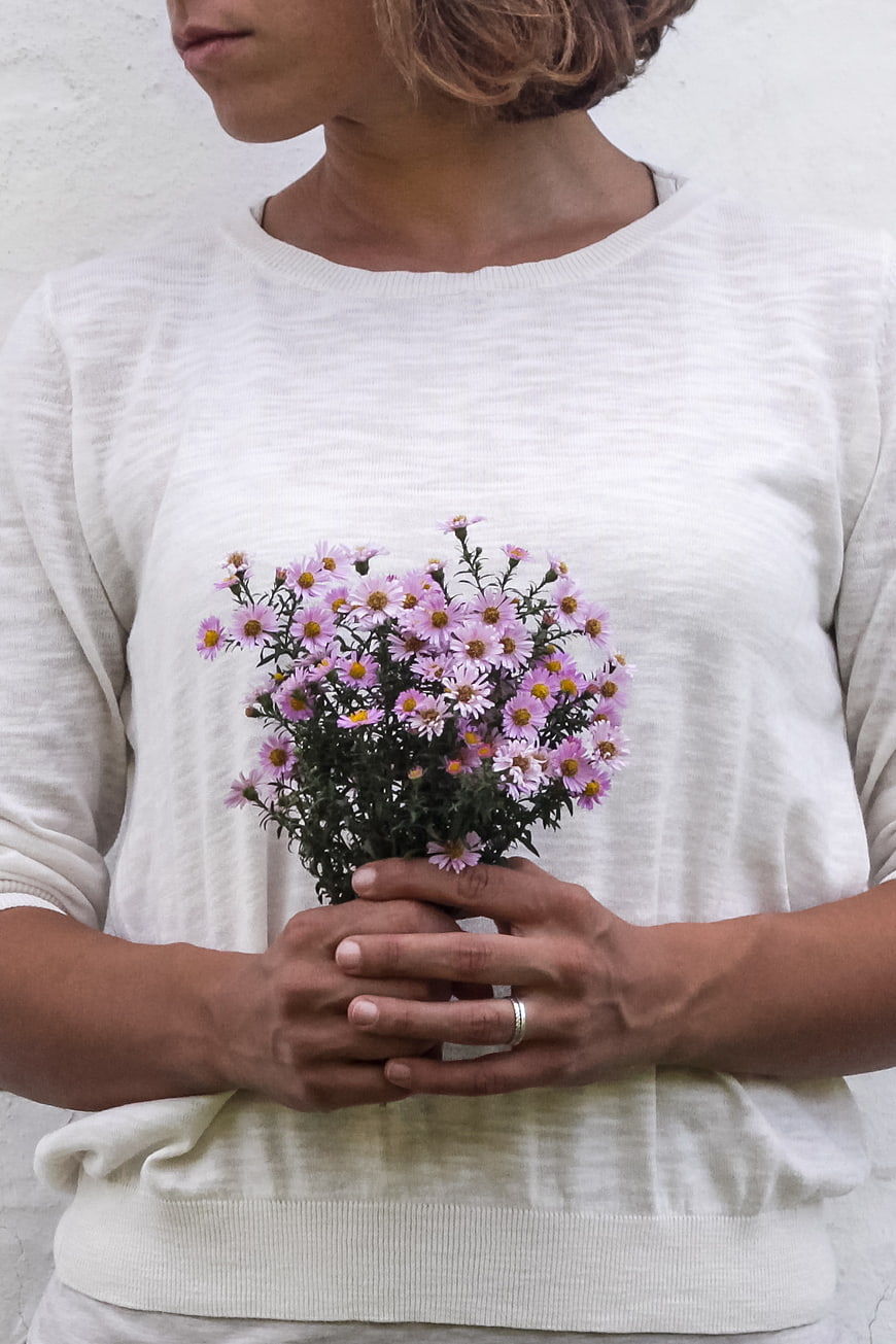 Woman holding small bouquet of purple flowers