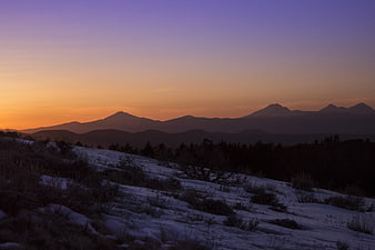 Snowy Mountain Landscape at Sunset with Purple and Orange Sky