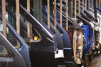 Row of car doors in auto parts recycling facility