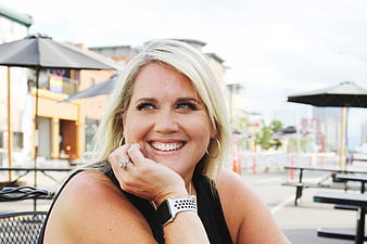 Happy blonde woman smiling at outdoor cafe patio