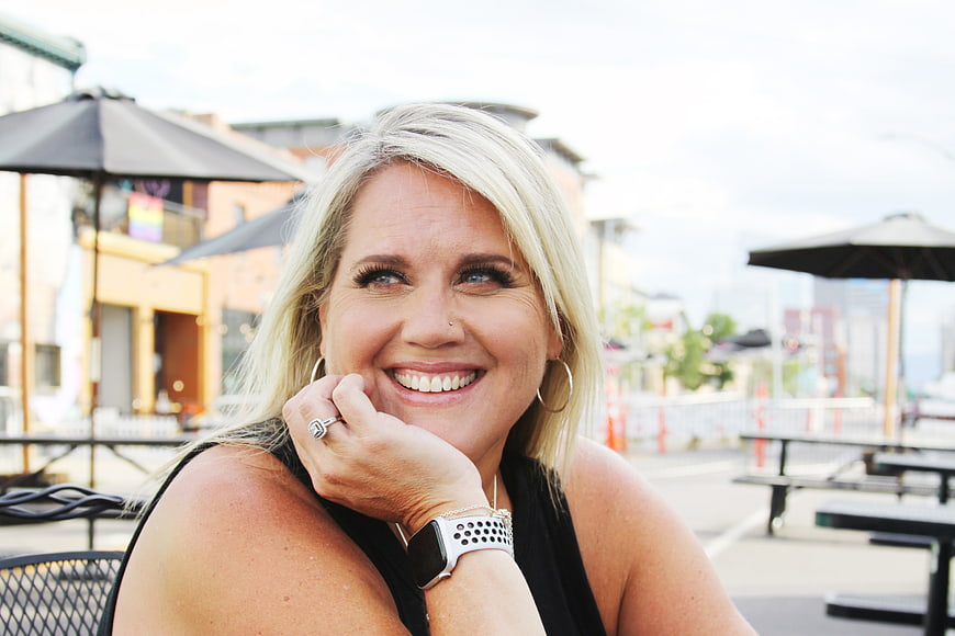 Happy blonde woman smiling at outdoor cafe patio