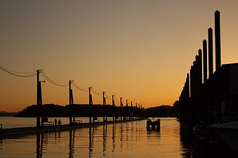 Silhouetted pier and harbor at golden sunset