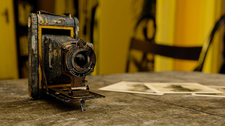 Vintage Rusty Camera on Wooden Table with Old Photographs