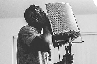 Man Singing into Microphone in Recording Studio