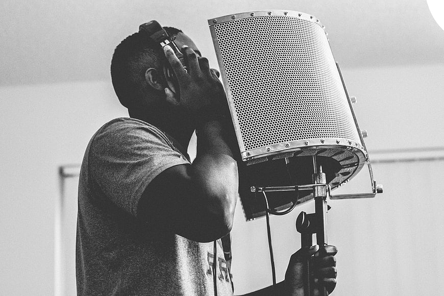 Man Singing into Microphone in Recording Studio