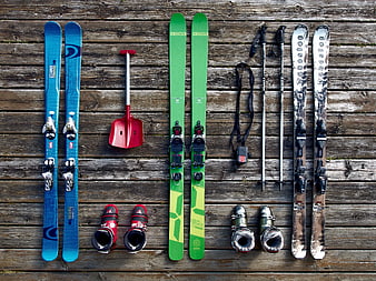 Flat lay of colorful ski equipment on wooden deck