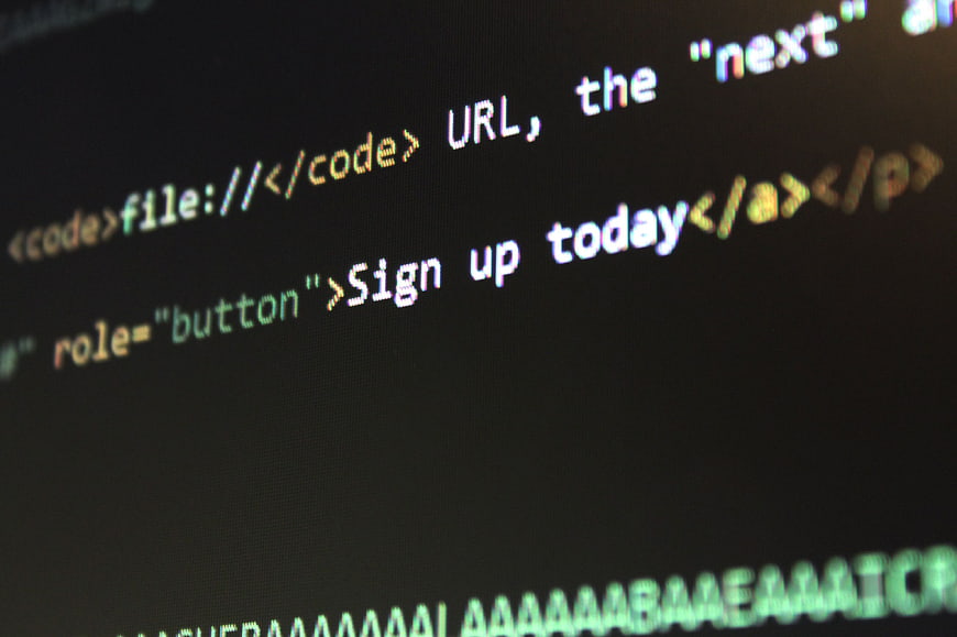Close-up of HTML code on a dark computer screen