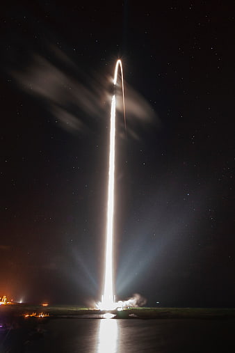Night rocket launch with bright trail and starry sky