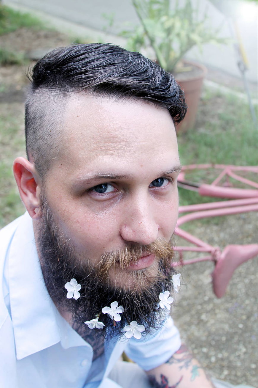 Portrait of man with beard and flowers in beard