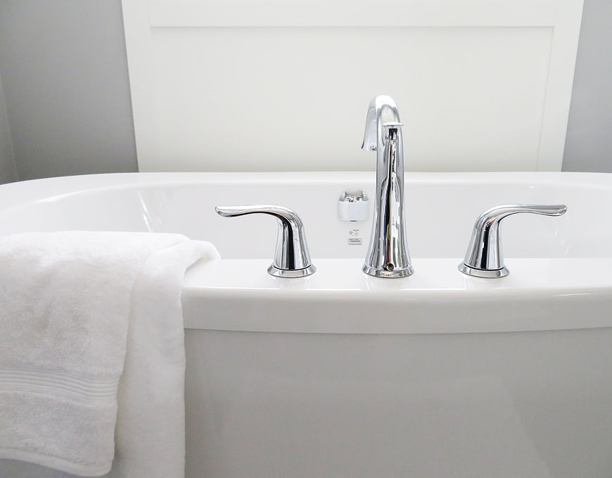 Modern white bathtub with chrome faucet and white towel