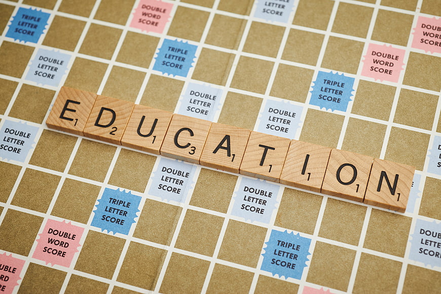 Scrabble tiles spelling education on game board