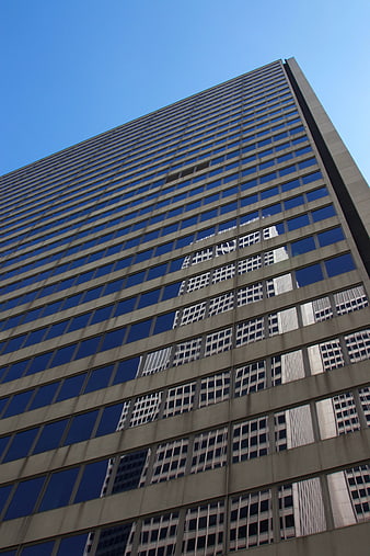 Low angle view of modern office building facade with blue sky