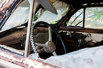 Rusty vintage car interior with checkered steering wheel