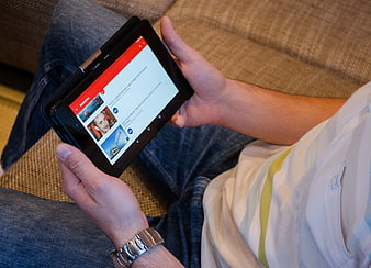 Person holding tablet computer showing video app interface