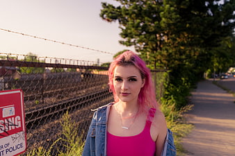 Portrait of young woman with pink hair near train tracks
