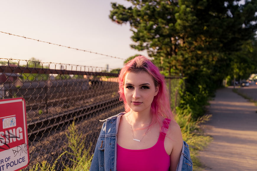 Portrait of young woman with pink hair near train tracks