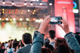Audience member recording live concert performance on smartphone