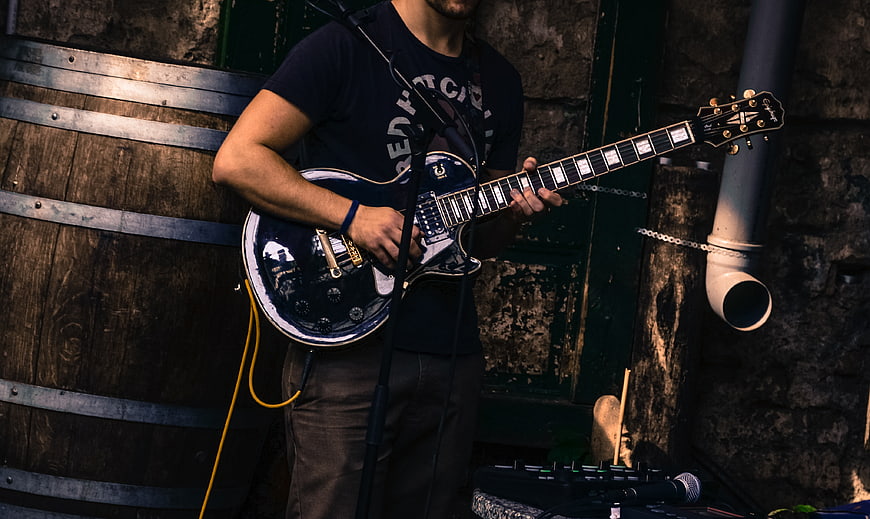 Male Guitarist Playing Electric Guitar on Street