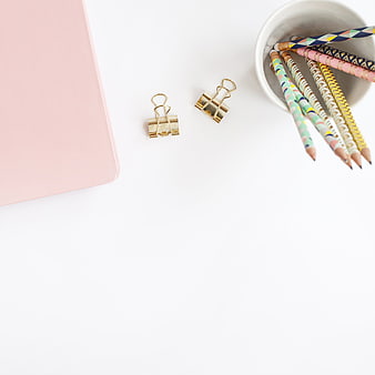 Minimalist pastel stationery flat lay with gold clips and pencils