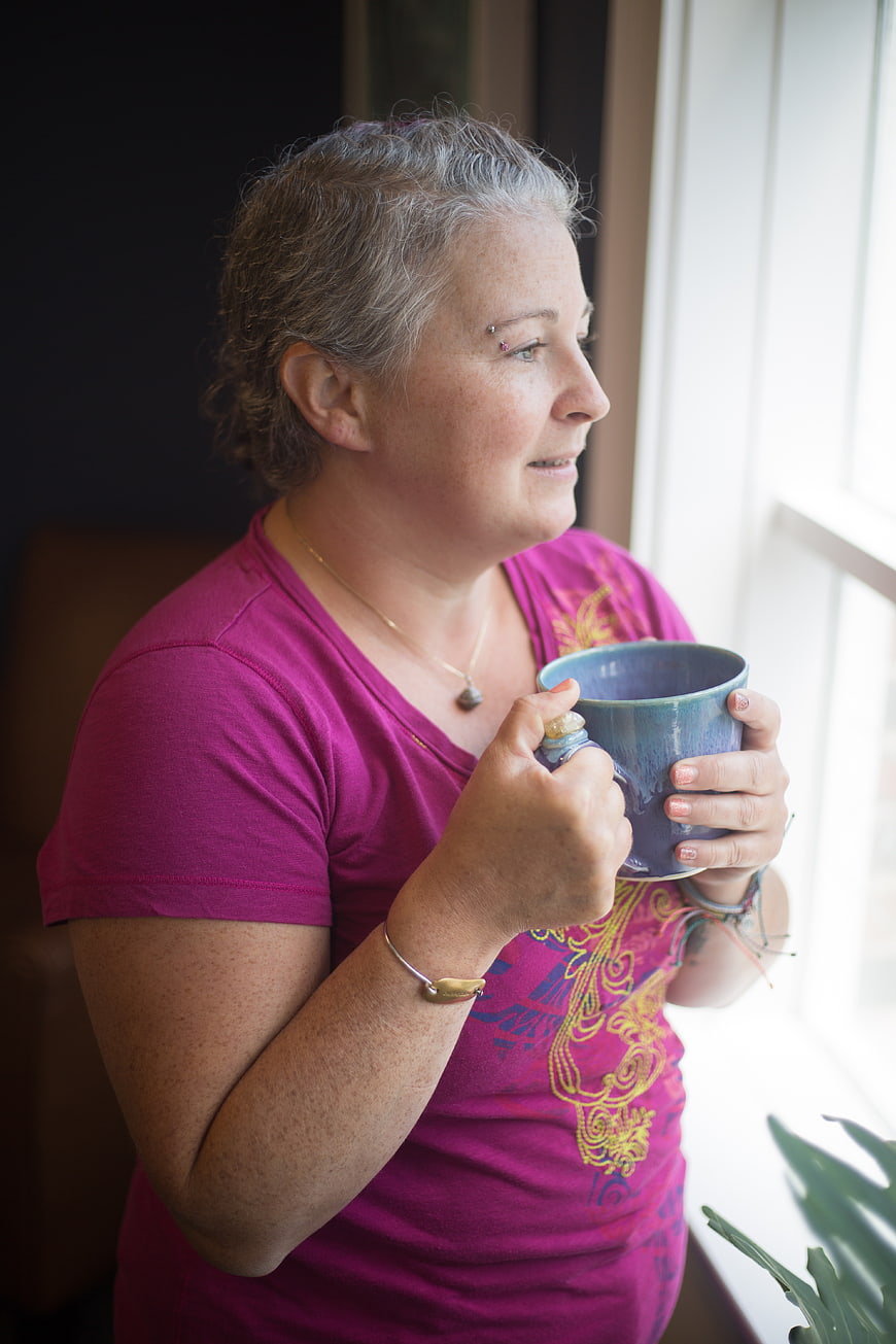 Senior woman holding blue mug looking out window