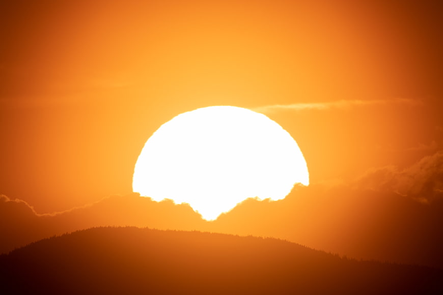 Giant Orange Sunset Sun Behind Mountain Silhouette