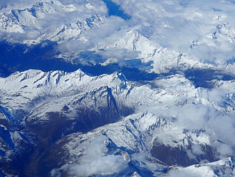 Aerial View of Snow-Covered Mountain Peaks and Clouds