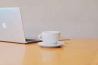 Minimalist Workspace with Laptop and White Coffee Cup