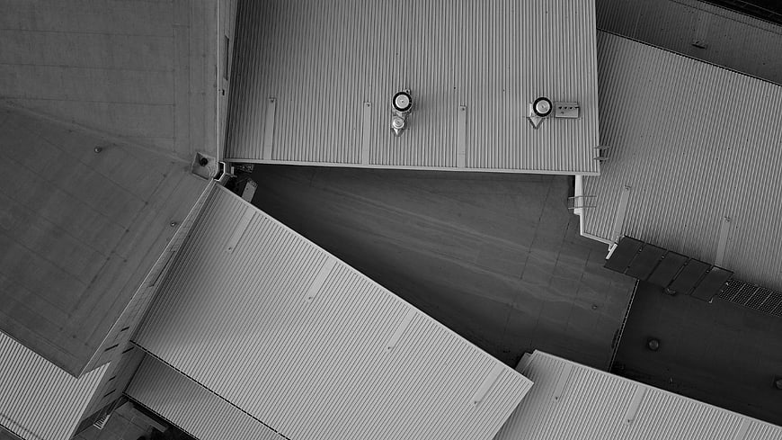 Aerial black and white view of industrial corrugated metal rooftops