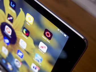 Close-up of tablet screen with app icons and battery indicator