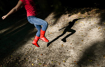 Woman Jumping in Red Boots in Forest