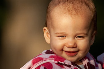 Close-up portrait of a smiling baby in a pink jacket