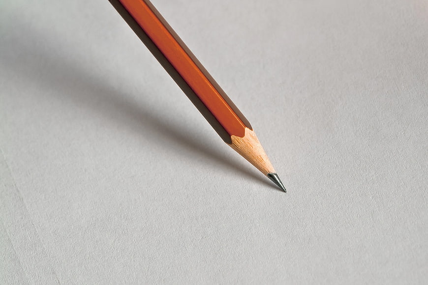 Close-up of orange pencil tip on white paper