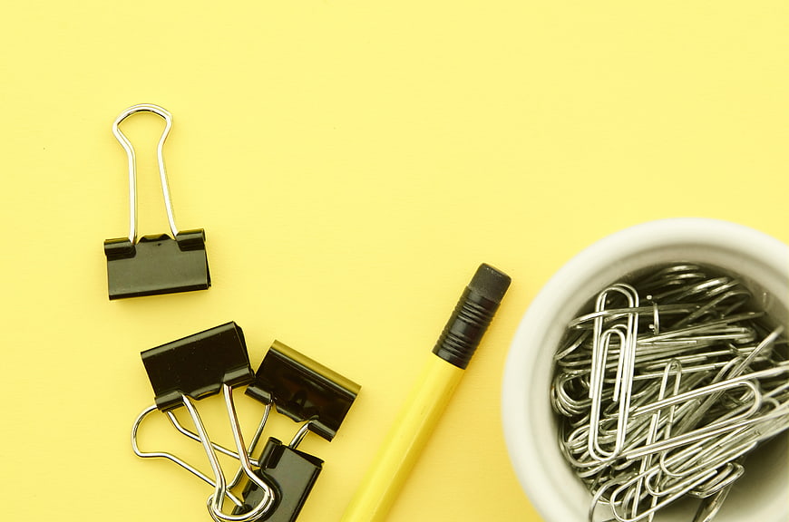 Flat lay of office supplies on yellow background with copyspace