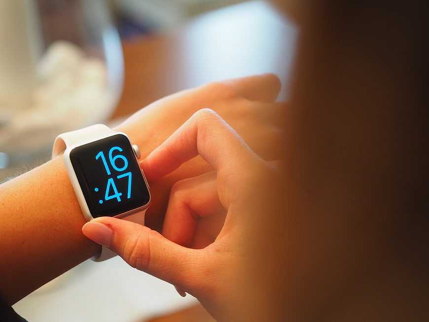Close-up of woman checking white smartwatch on wrist