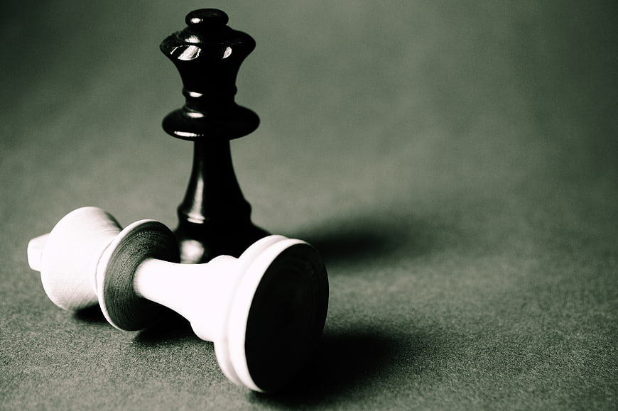 Black Chess Queen Standing Over Fallen White King