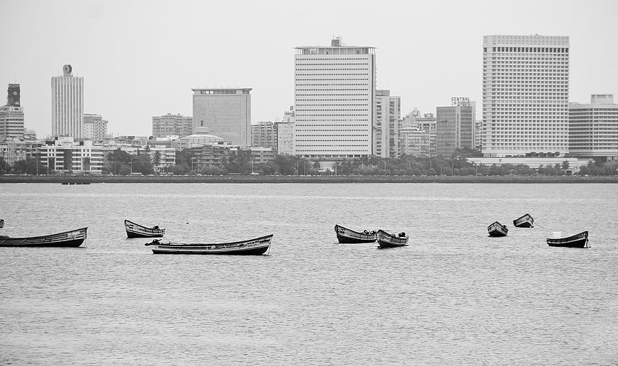 Black and white cityscape with boats on water