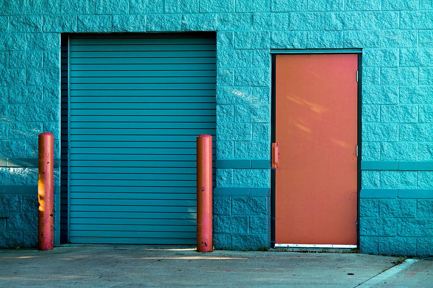 Colorful Teal Brick Wall with Orange Door and Garage