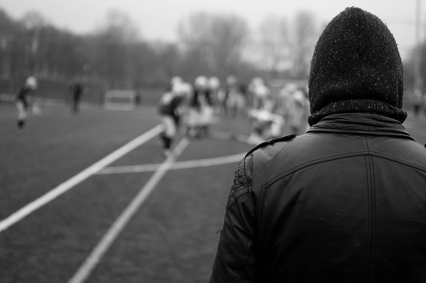 Spectator watching rugby match in winter black and white