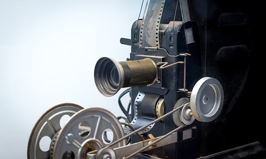 Close-up of vintage film projector with reels and filmstrip