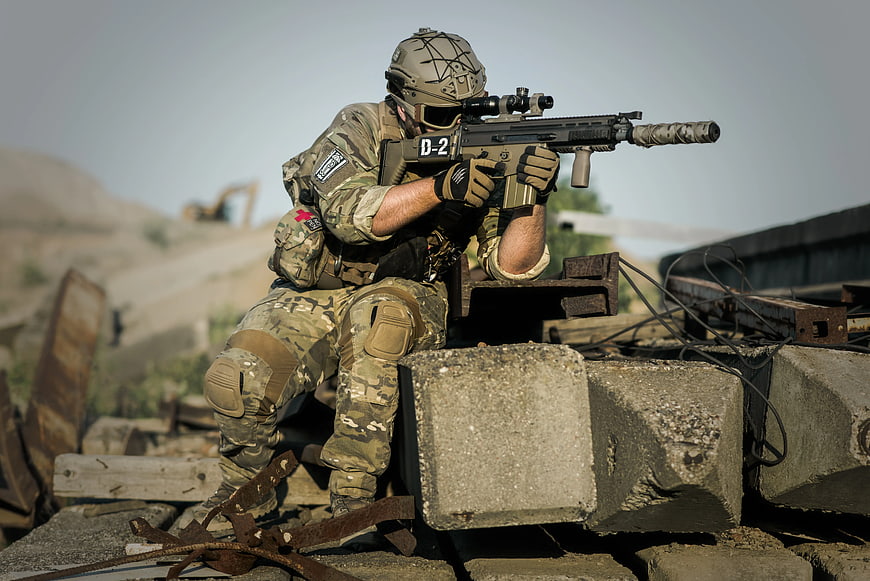 Soldier in Camouflage Taking Cover with Rifle