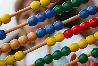 Close-up of colorful wooden abacus beads with blurred child