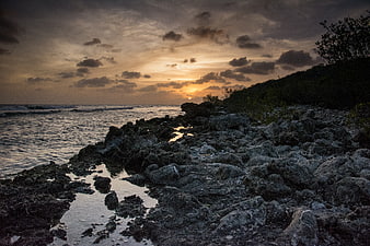 Dramatic Sunset Over Rocky Coastal Shoreline