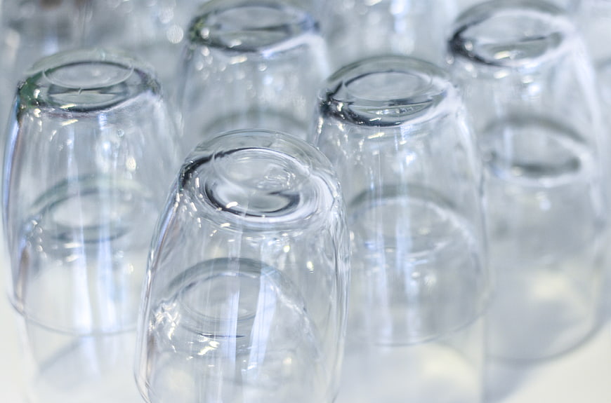 Stacked Clear Glass Juice Glasses on White Surface