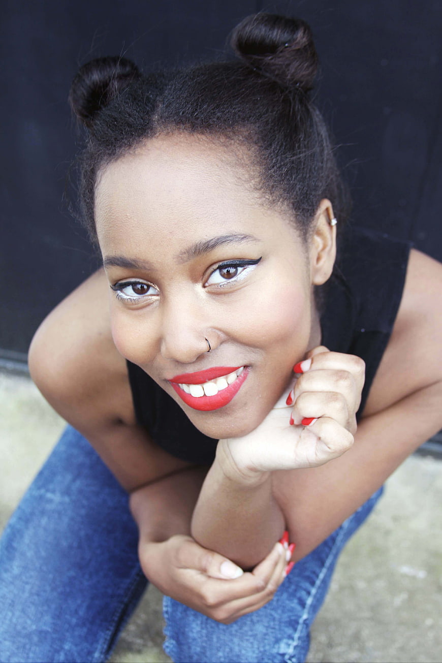 High angle portrait of smiling woman with space buns and red lipstick