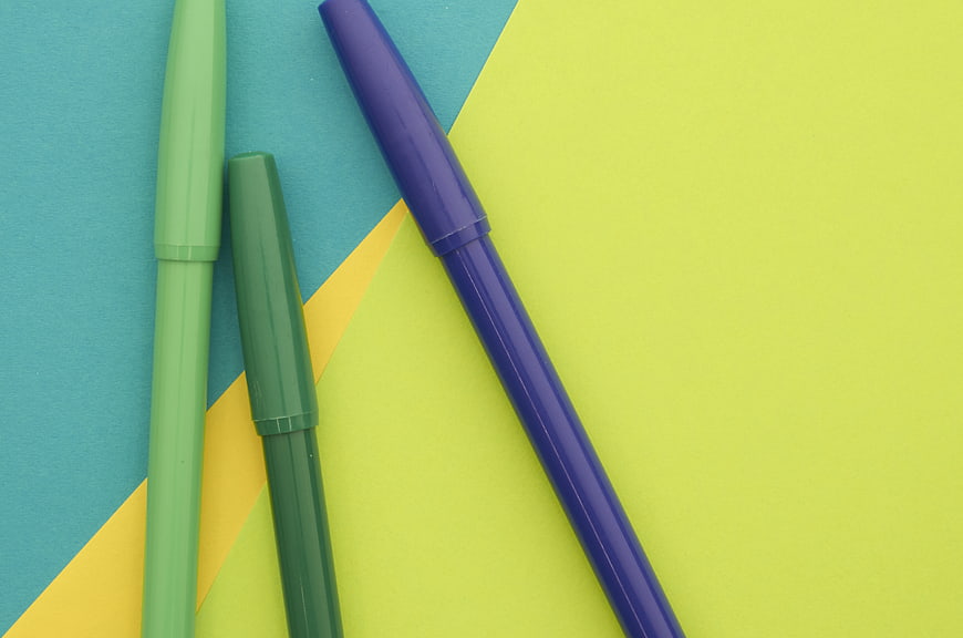 Colorful markers on geometric pastel background