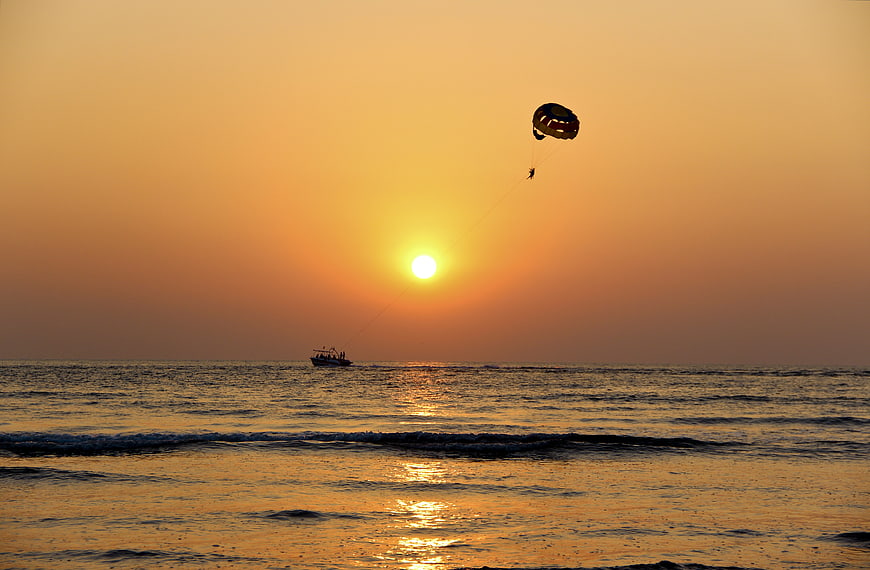 Parasailing Silhouette Over Ocean at Golden Sunset