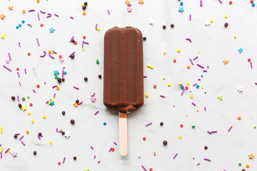 Chocolate Ice Cream Bar with Sprinkles on White Background