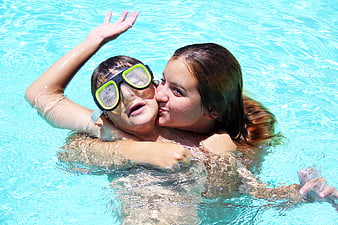 Brother and Sister Playing and Hugging in Swimming Pool